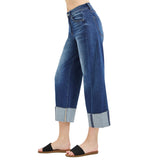 Side view of a model in dark slouchy barrel crop cuffed jeans, highlighting the curved barrel silhouette, soft stretch denim, and cuffed hem.