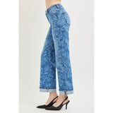Side view of a model in Risen mid rise floral print straight ankle jeans, highlighting the straight‑leg silhouette, ankle length, and printed accents.