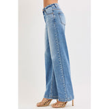Side view of model in High Rise Wide Baggy Jeans highlighting the wide leg and high‑rise silhouette.