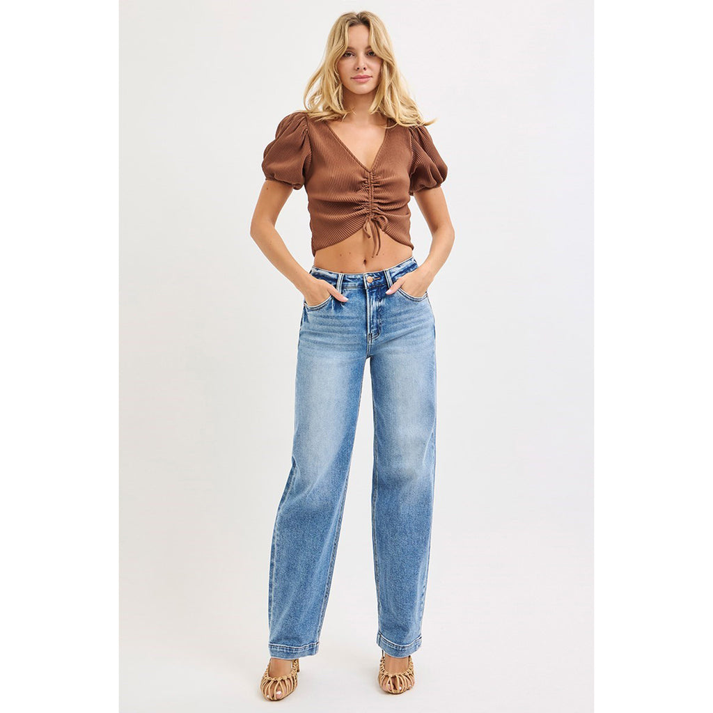 Model with hands in pockets wearing High Rise Wide Baggy Jeans showing the front fit, high waist, and relaxed wide leg.