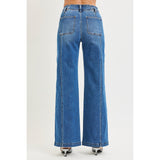 Back view of a model wearing high rise wide leg jeans with curved back seam detail, showing the lifted fit, clean pockets, and wide‑leg shape.