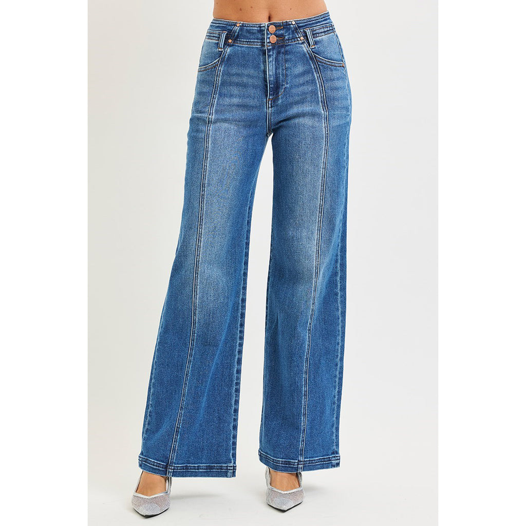 Model wearing high rise wide leg jeans with front and back curved seam detail, front view showing the structured waistband, curved seams, and wide‑leg silhouette.