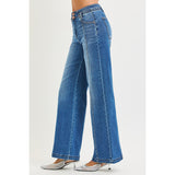 Side view of a model in high rise wide leg curved seam jeans, highlighting the draped wide leg, smooth high‑rise fit, and forward seam shaping.