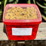 Red container filled with pineapple rings horse treats on a wooden surface