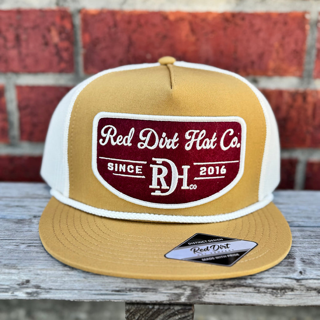 Mustard cap with white rope and maroon and white red dirt logo.