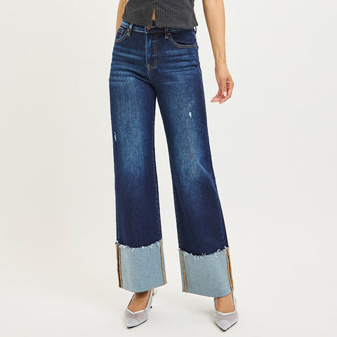 Dark blue jeans with tall cuff at the bottom and small distressed details on the thighs.