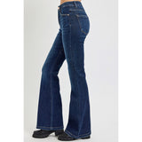 Side‑view of model wearing dark tummy control high rise flare jeans, highlighting the slimming high rise and dramatic flare silhouette.