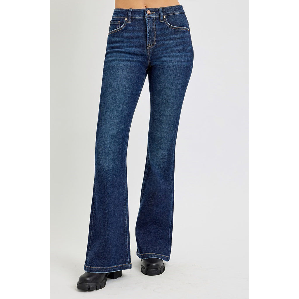 Model wearing dark tummy control high rise flare jeans facing forward, showing the smooth front panel, flattering high rise, and wide flare leg.