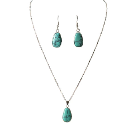 Flay Lay of set, earrings are oval turquoise stone on a dangle hook earring and necklace has a small turquoise oval pendant on a silver chain. 