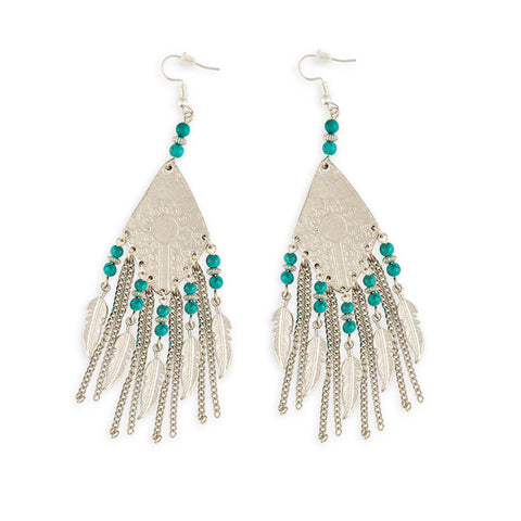 Flat silver earrings in a diamond shape with a stamped sun design and turquoise stones, chains, and feather dangling below. 