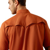 Back of man wearing an orange shirt with ariat brand logo.