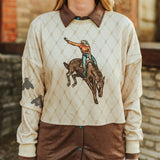 Light tan shirt with diamond pattern and bronc rider graphic in the middle. Shirt is slightly cropped and long sleeve.
