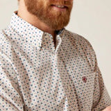 Close up view of white long sleeve button down shirt with front chest pocket. Includes small red and blue patterned details. 