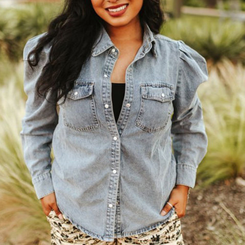 Model wearing Women’s Light Wash Stretch Denim Puff Sleeve Shirt, showing pearl snap front, pockets and puff sleeve detail.