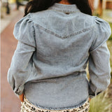 Back view of model wearing Women’s Light Wash Stretch Denim Puff Sleeve Shirt, showing yoke detail and light wash denim fabric.