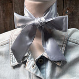 Silver/grey twilly tied around mannequin neck in a bow shape. 