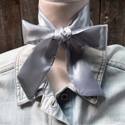 Silver/grey twilly tied around mannequin neck in a bow shape. 