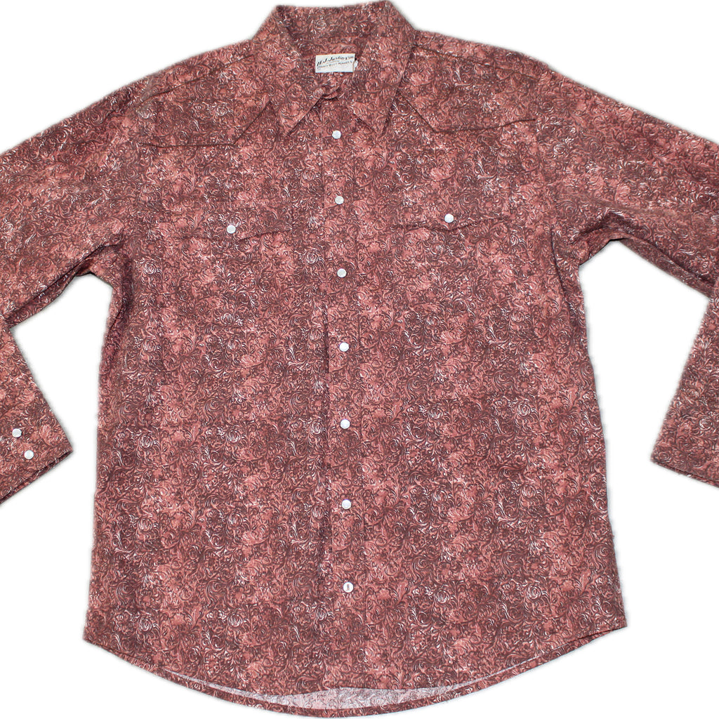 Flat lay of Brown pearl snap shirt with a floral leather print and two snap chest pockets. 