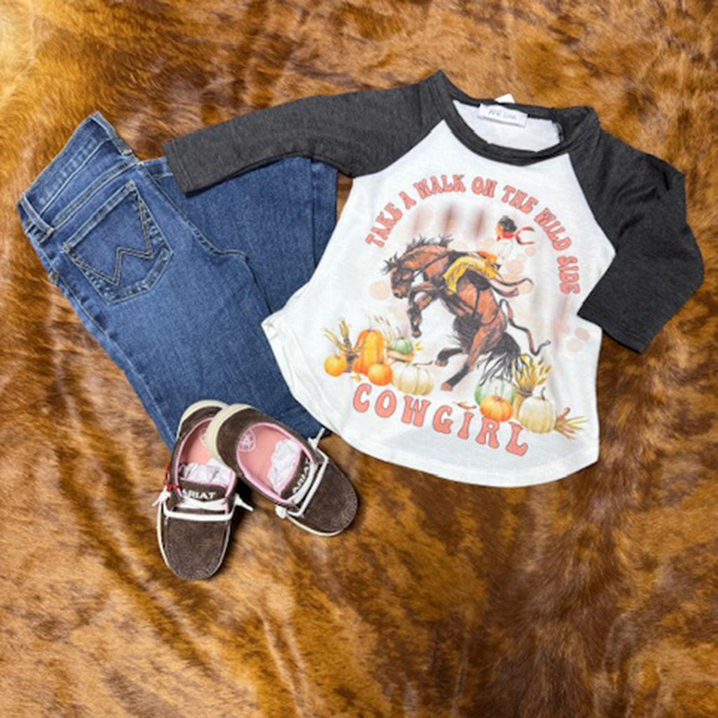 Walk on the Wild Side Shirt with Bronc Graphic on front laying with jeans and shoes