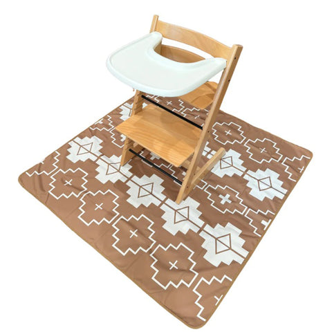 tan and white aztec splat mat with high chair on it