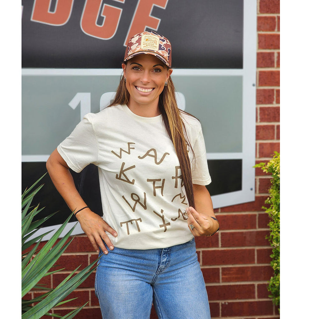 Brans on a tan crew neck shirt 