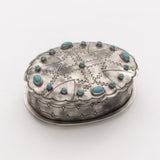 Top view of the oval silver box showing its stamped pattern and turquoise centerpiece.