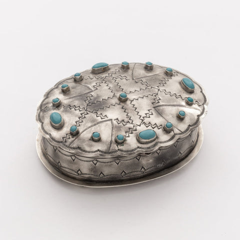 Top view of the oval silver box showing its stamped pattern and turquoise centerpiece.