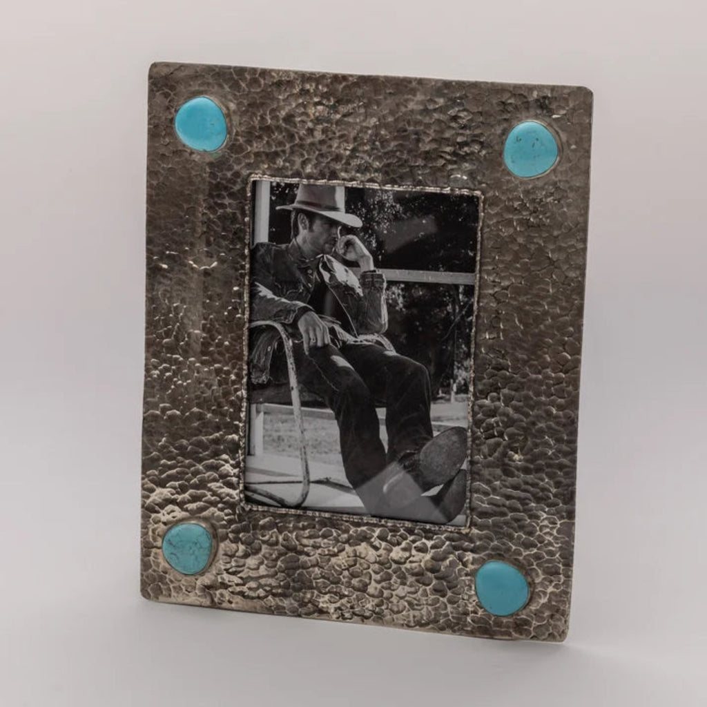 Front view of the silver photo frame showing its textured dimpled border and four turquoise stone accents.
