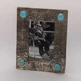 Front view of the silver photo frame showing its textured dimpled border and four turquoise stone accents.