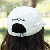 White cap with cruel denim on the back.