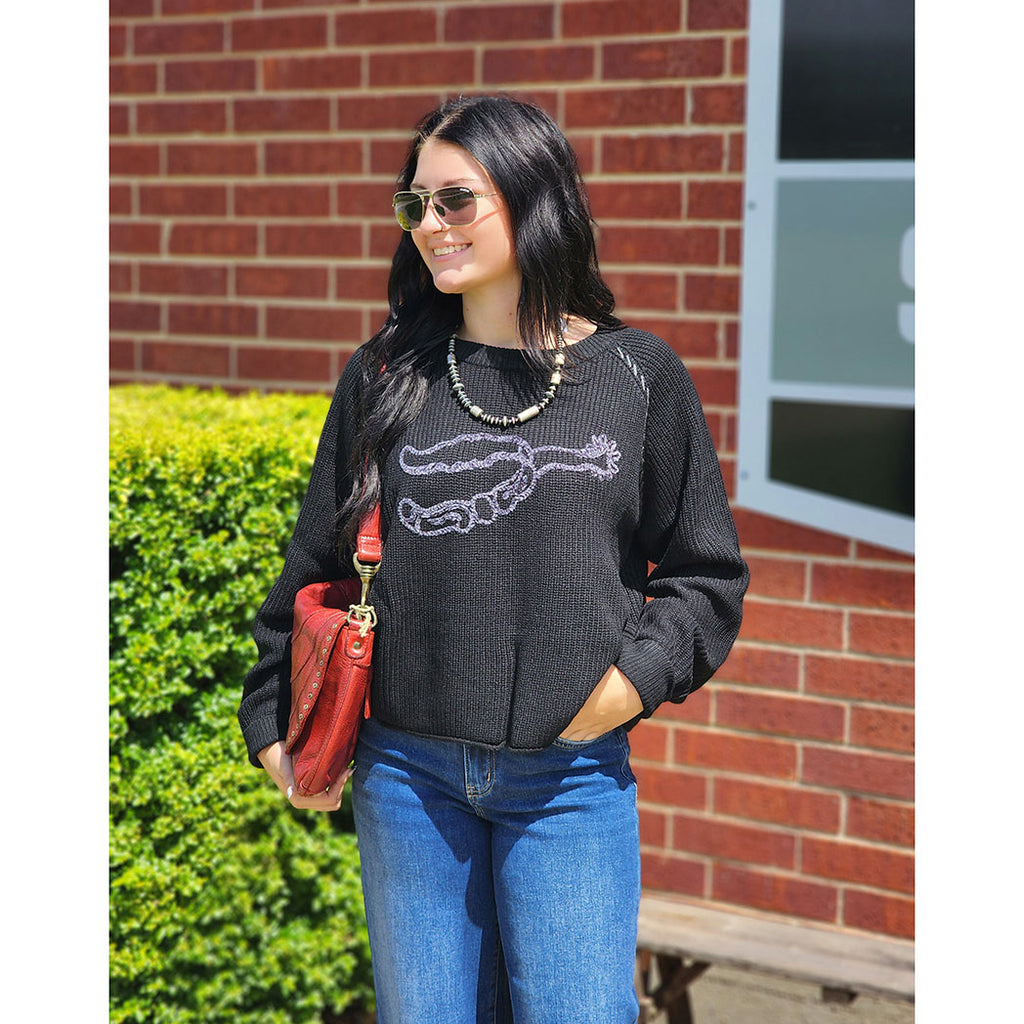 Black knit sweater, silver spur on the front 