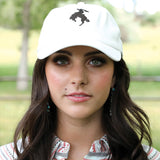 White baseball cap with black bronc rider silhouette.