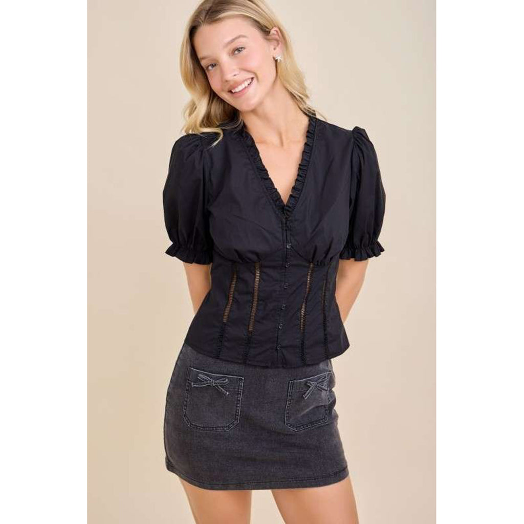 Model wearing a black ruffle V‑neck puff sleeve blouse, front view showing the romantic ruffles, flattering neckline, and soft feminine silhouette.