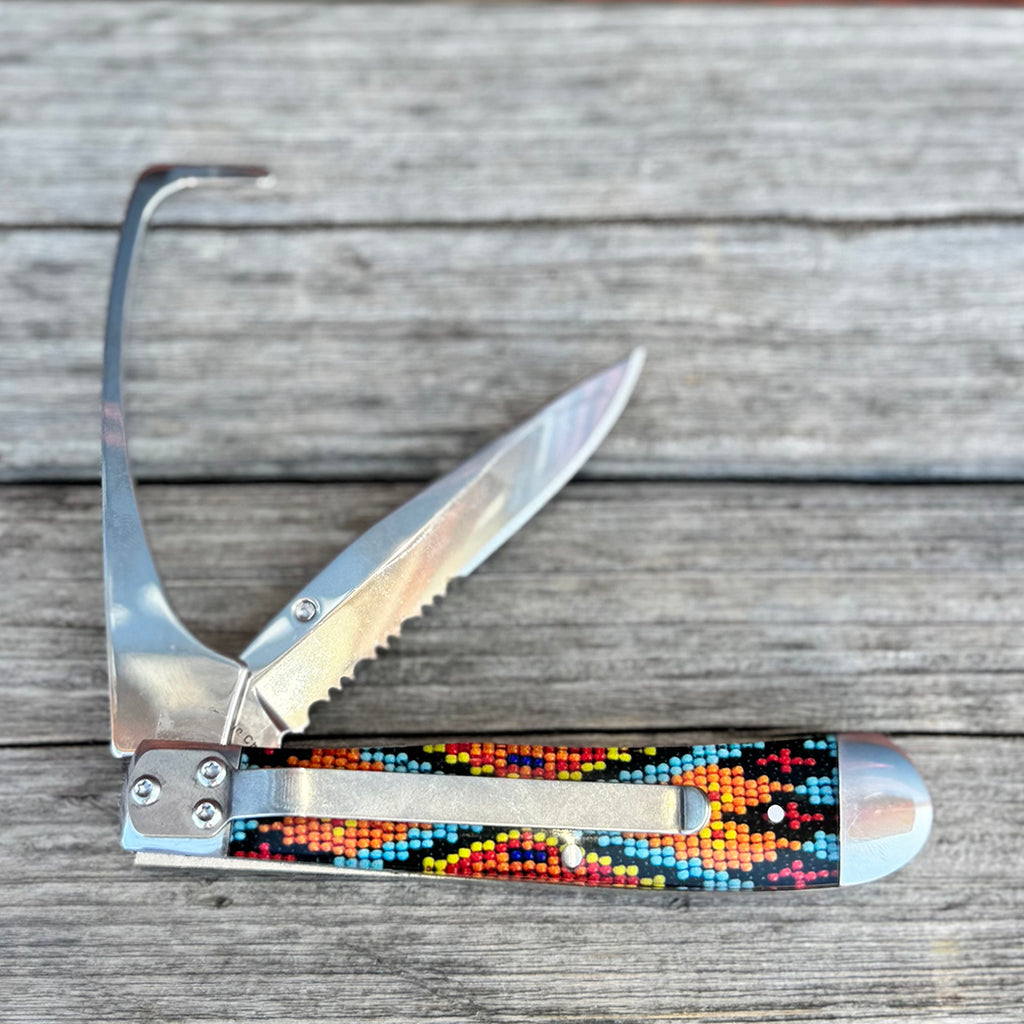 Serrated pocket knife with hoof pick and orange, blue and black beaded design.