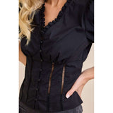 Close‑up of a model wearing a black ruffle V‑neck puff sleeve blouse, highlighting the delicate ruffle trim, soft fabric texture, and romantic neckline detail.