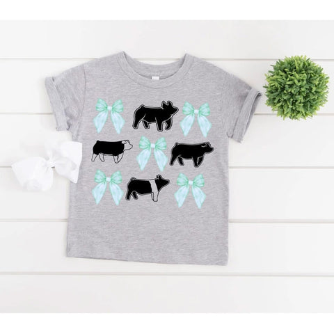 Front view of girls shirt featuring playful pigs and blue bow illustration
