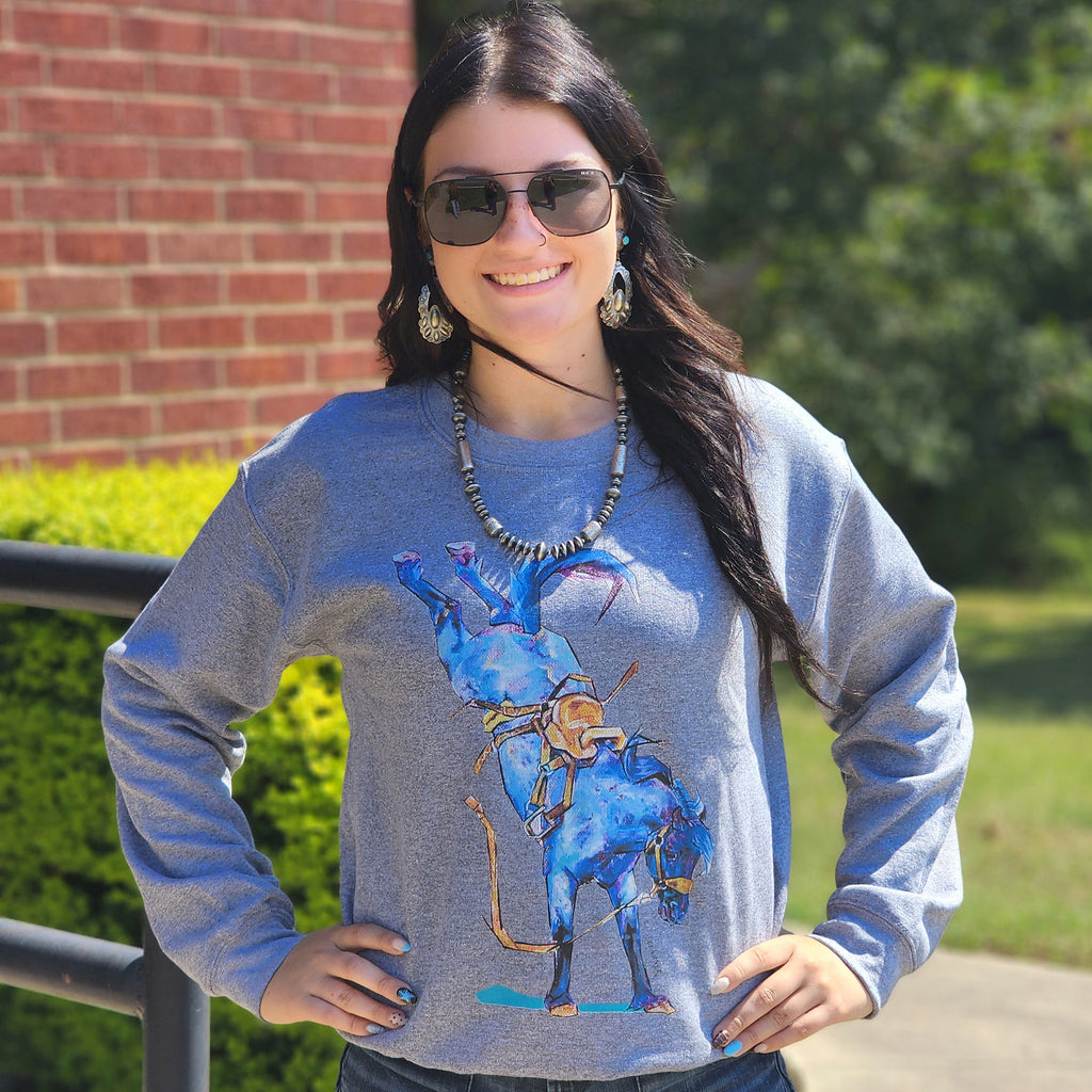 Woman wearing a gray sweatshirt with a blue bronc graphic design.
