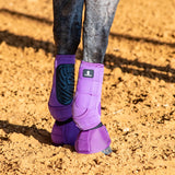 Back side view of violet classic fit sling boots and bell boots on a horse standing in the dirt.