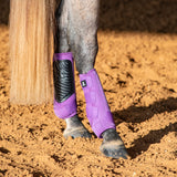 Violet leg boots with black padding shown on a grey horse's legs.