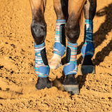 Four pueblo sling boots on a horse standing in the dirt.