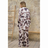 Back view of a woman wearing a cream and brown cow print outfit