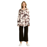 Woman wearing a cream and brown cow print long sleeve shirt
