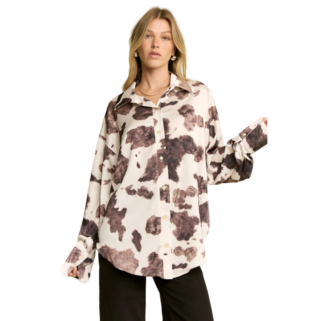 woman wering a cream and brown cow print long sleeve shirt