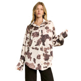woman wering a cream and brown cow print long sleeve shirt