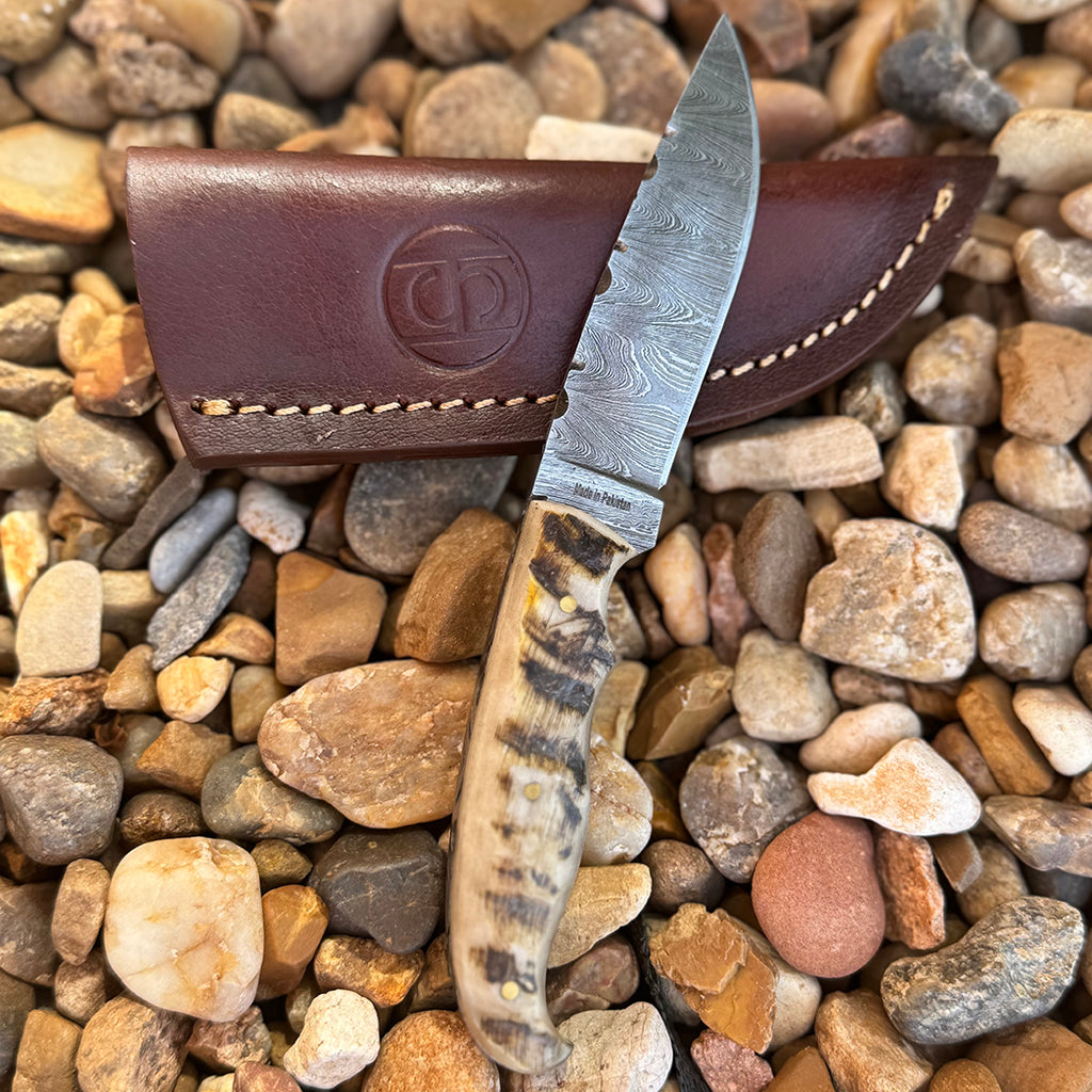 Damascus blade knife with ram horn handle.