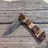 Partially closed Damascus blade knife with stag and wood handle.