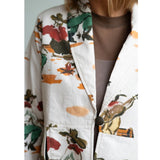 Close up of a woman wearing a colorful western scene print blazer