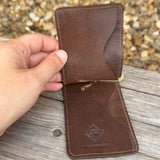 Inside of white and brown ostrich money clip with card holder slots inside.