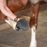 Person holding the horses leg up, where the bottom of the medicine boot shows.