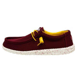 A maroon HEYDUDE shoe shown from the side angle. The laces are yellow and the sole features a dotted pattern..